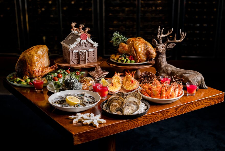 A Christmas buffet including seafood, ham and turkey plus a gingerbread house and a statue of a reindeer.