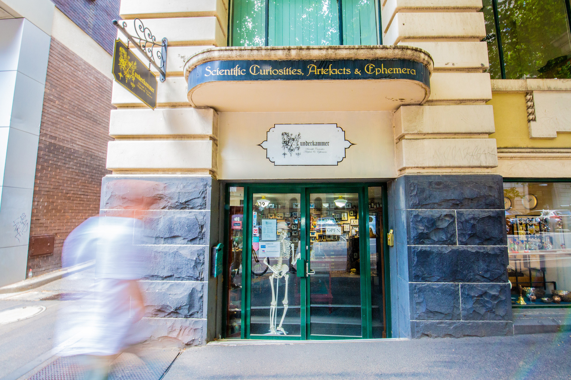The exterior of a shop entrance in an art deco building. 