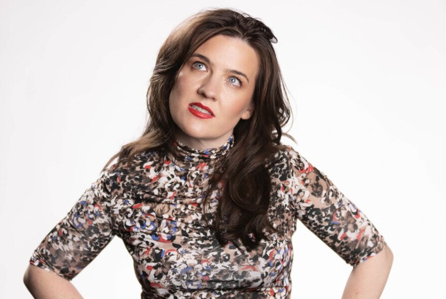 Comedian Rose Callaghan, with long straight brown hair, her head tilted upwards slightly.