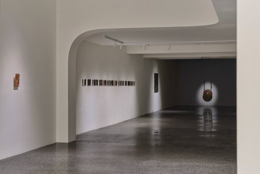 The interior of Project8 Gallery with small artworks hanging on the white wall, and a polished concrete floor.