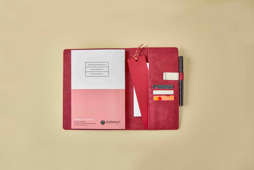 A journal in a folder with pockets, pen and strap.