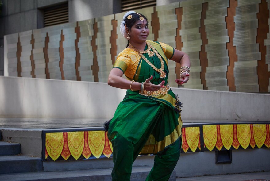 A classical Indian dancer performing a traditional dance in a foyer or outdoor area, as part of Diwali celebrations.