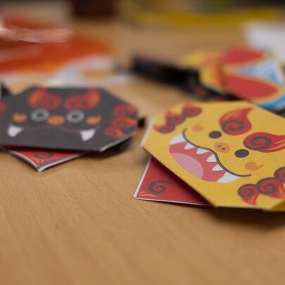 Paper Japanese animal masks on a desk.
