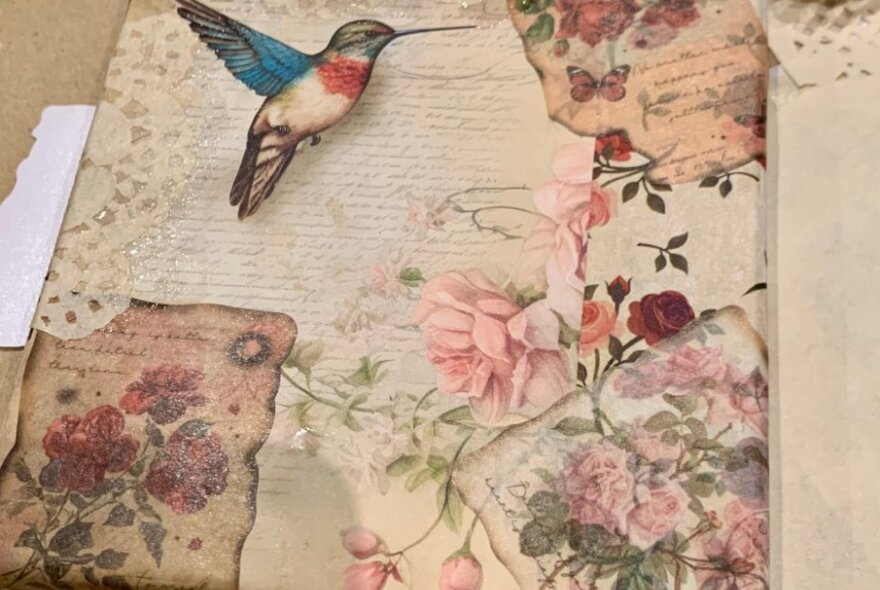 A box decorated with floral papers and a bird sticker.