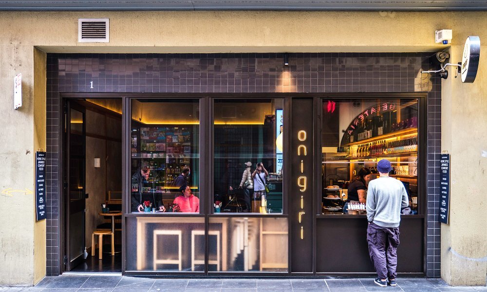 A man ordering from the window of an onigiri cafe.