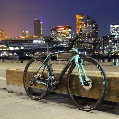 Bike resting on a bench city with city skyline in the background.