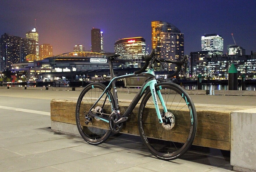 Bike resting on a bench city with city skyline in the background.
