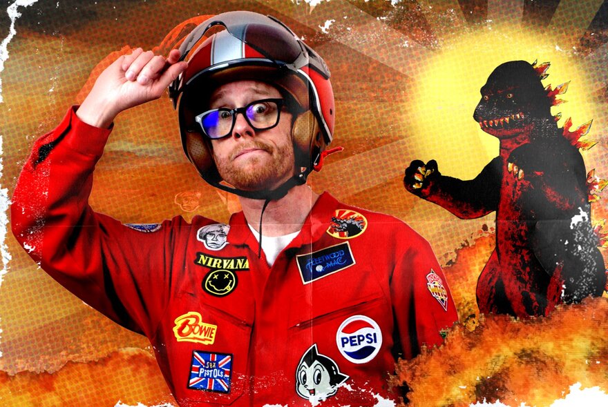 A man in a red racing suit with patches sewn all over it, wearing a helmet and glasses with a cartoon godzilla in the background.