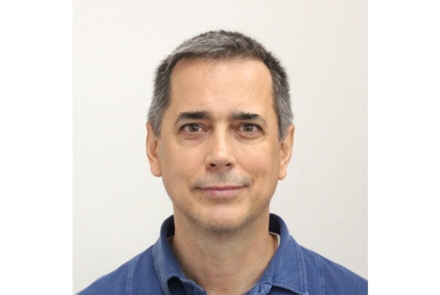 Anthony J Spires, with short grey hair, wearing a blue shirt.
