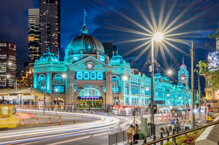 Flinders Street Station illuminated blue at night.