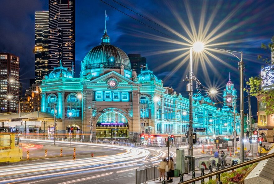 Flinders Street Station illuminated blue at night.