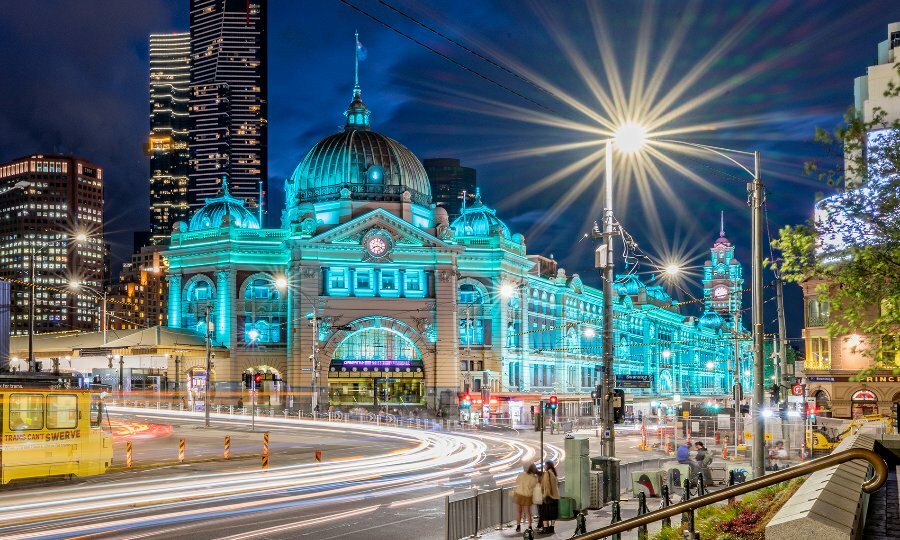 Flinders Street Station illuminated blue at night.