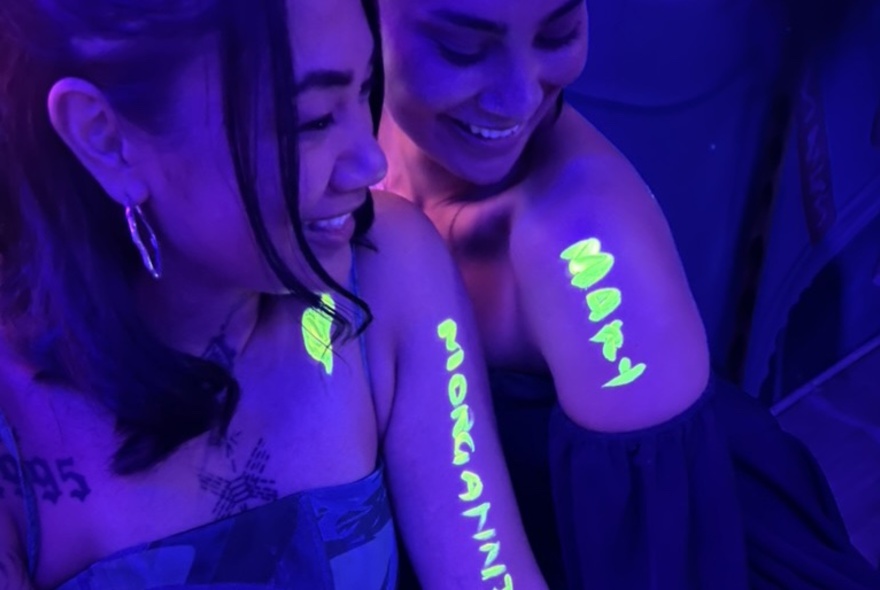 People with glow in the dark writing on their arms.