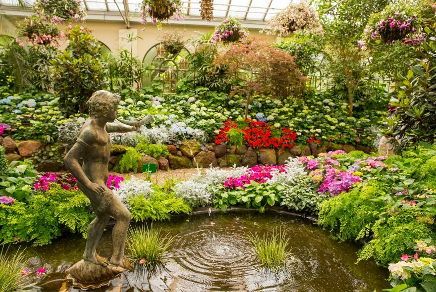 Interior shot of fountain and gardens inside the Conservatory in Fitzroy Gardens. 