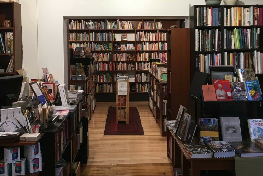 Lots of books for sale on shelves at Books For Cooks store.