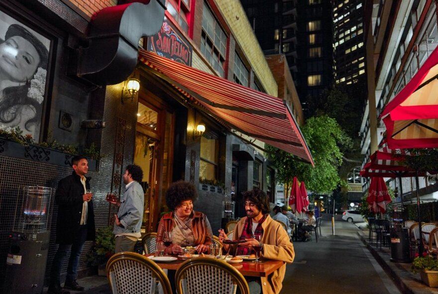 Two people at a table in a laneway