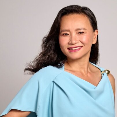 Journalist Cheng Lei, wearing a loosely cut pale blue draped top. 
