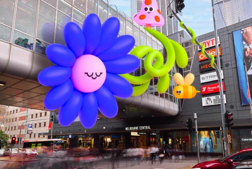 Large cartoon flower and figures decorating the Melbourne Central bridge walkway.