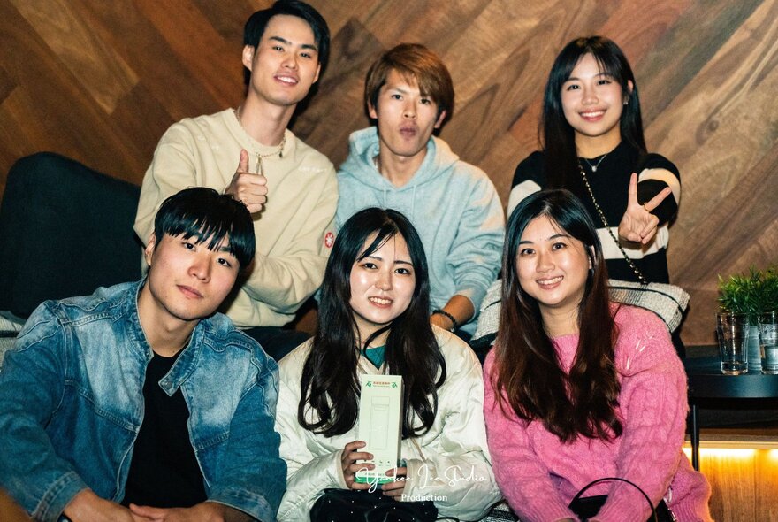 A group of six people in two tiers posing and smiling. 
