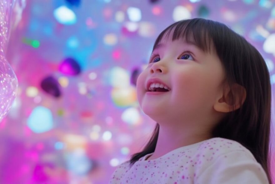 Delighted child surrounded by glittering abstract shapes.