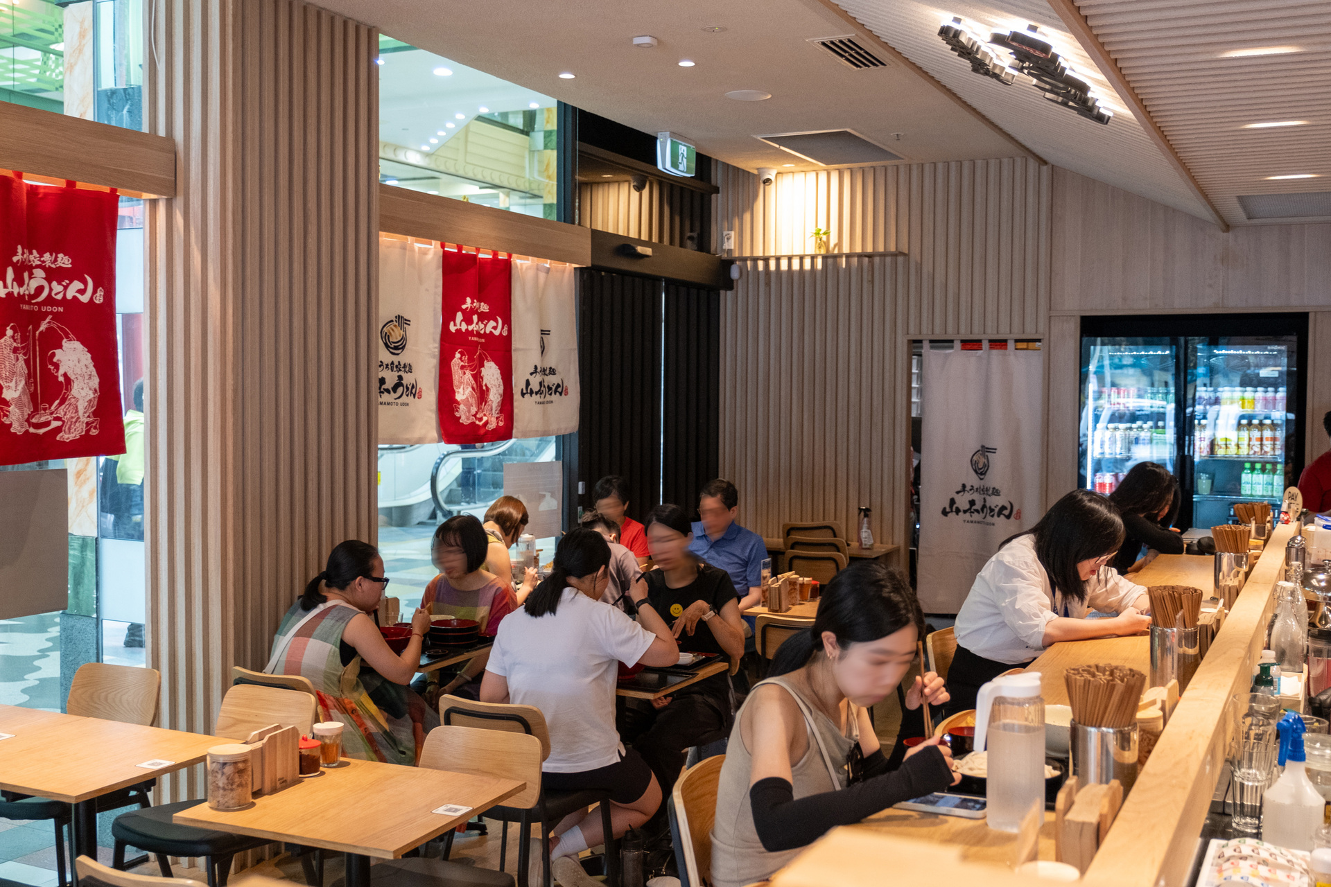 People are dining inside a Japanese-style udon noodle restaurant
