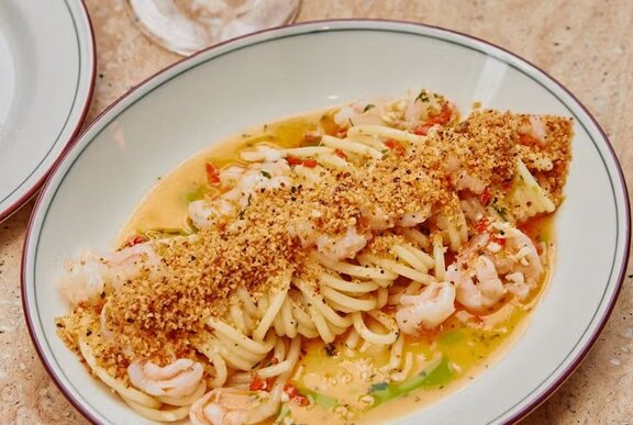A plate of spaghetti with a creamy prawn sauce.