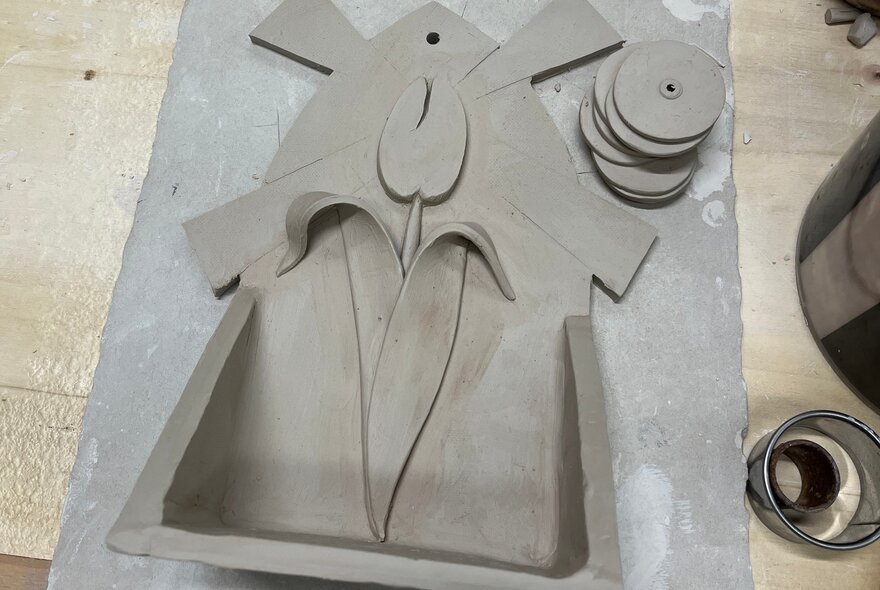 Grey shrine in the shape of a windmill with tulip design.
