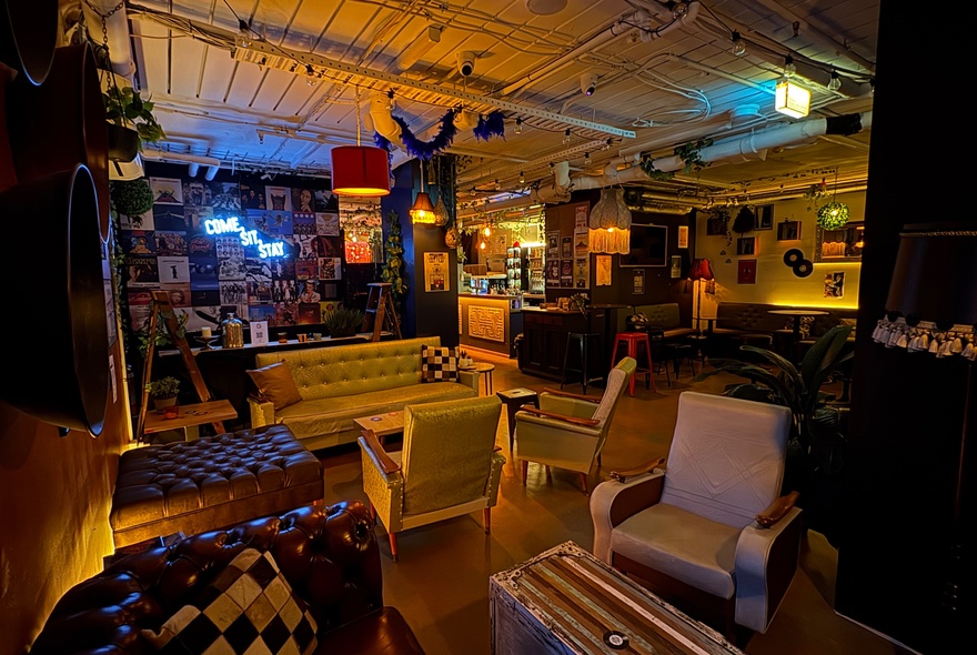 Venue with couches, armchairs and picture frames on the walls.