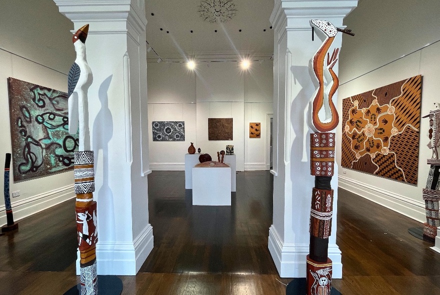 Gallery featuring large-scale Indigenous paintings and totemic sculptures.