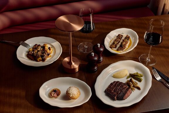Meat dishes on plates on a wooden table.