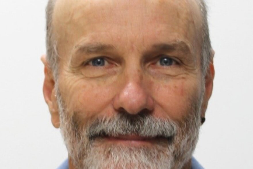 Man with a grey beard and freckled face.