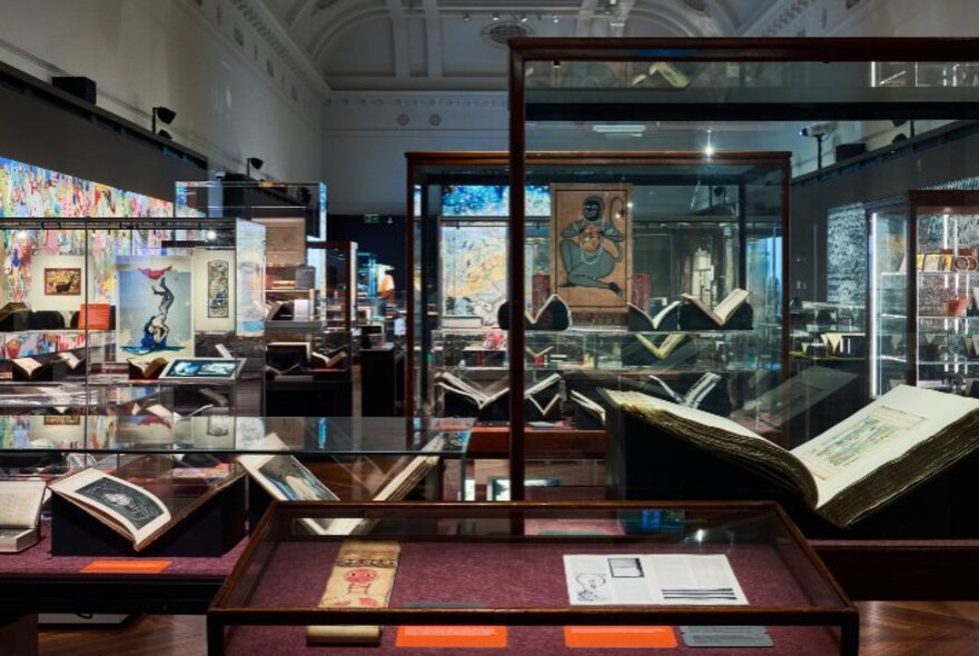 Books opened at specific pages behind glass at the State Library of Victoria. 