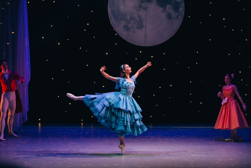 A ballerina in a ruffled blue gown mid-pirouette.