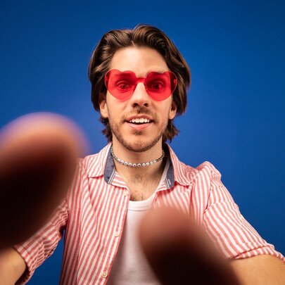 Man wearing red sunglasses taking a selfie.