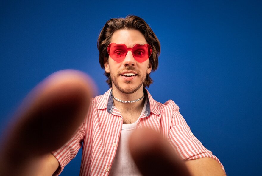Man wearing red sunglasses taking a selfie.