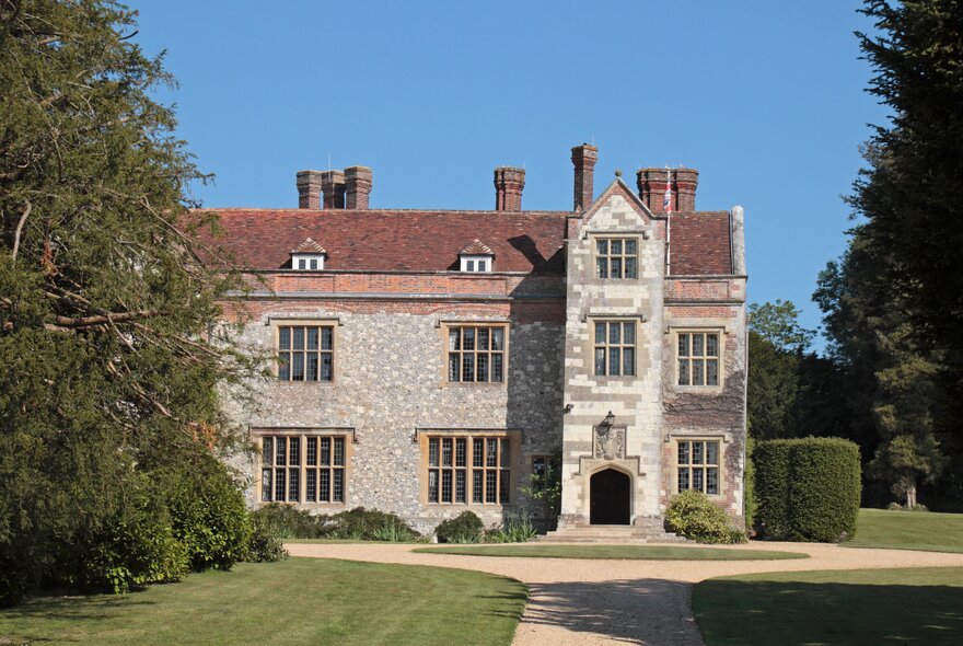 The English country manor house, Chawton, on a sunny day with large trees around it. 