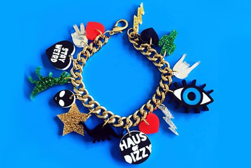 Nceklace with charms including a star and eye, on a blue background.