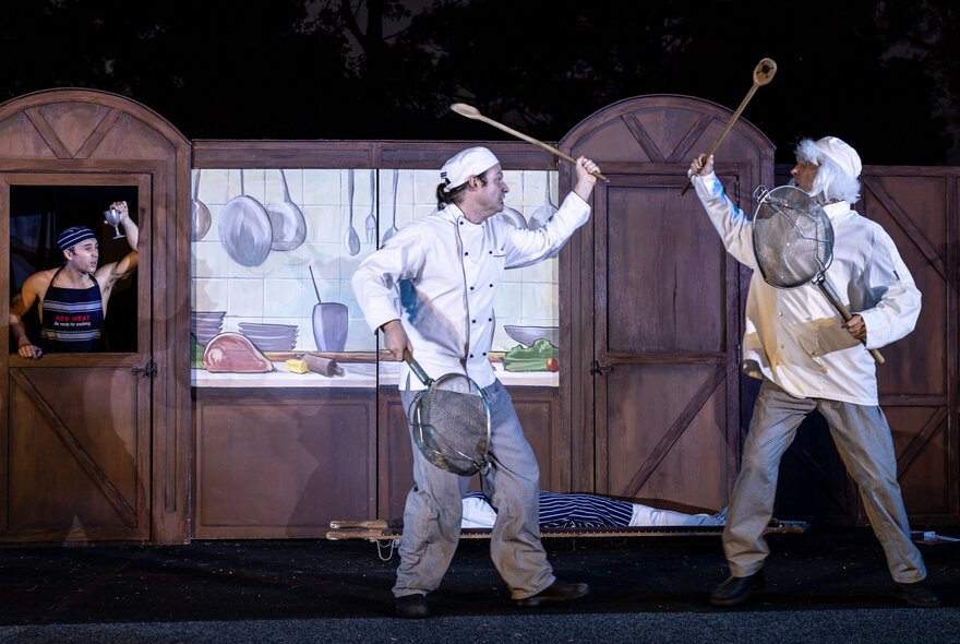 Two performers fight with kitchen implements, dressed as chefs. 