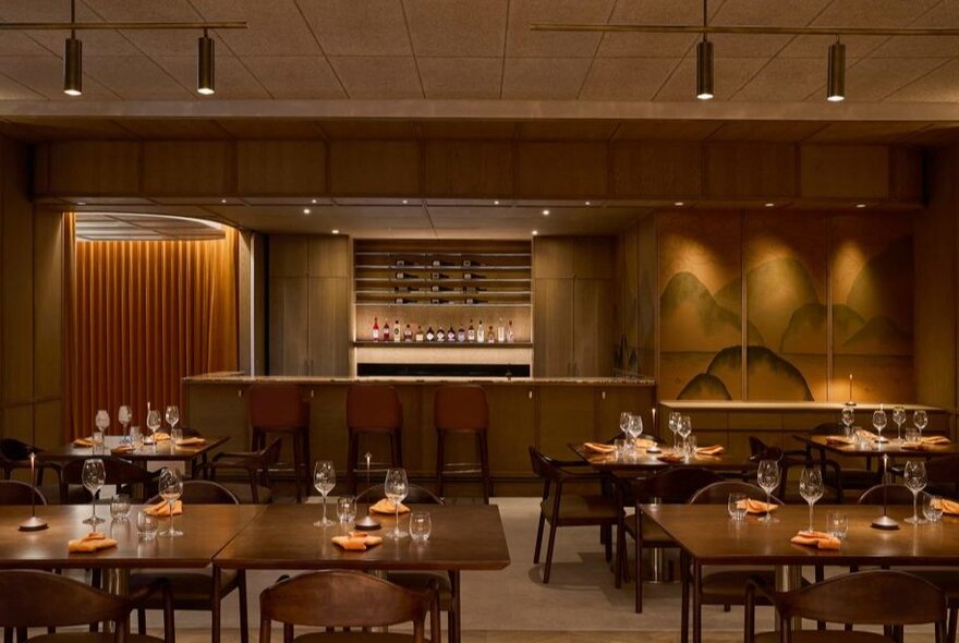 Formal dining room with tables and chairs, bench seating and bar area.