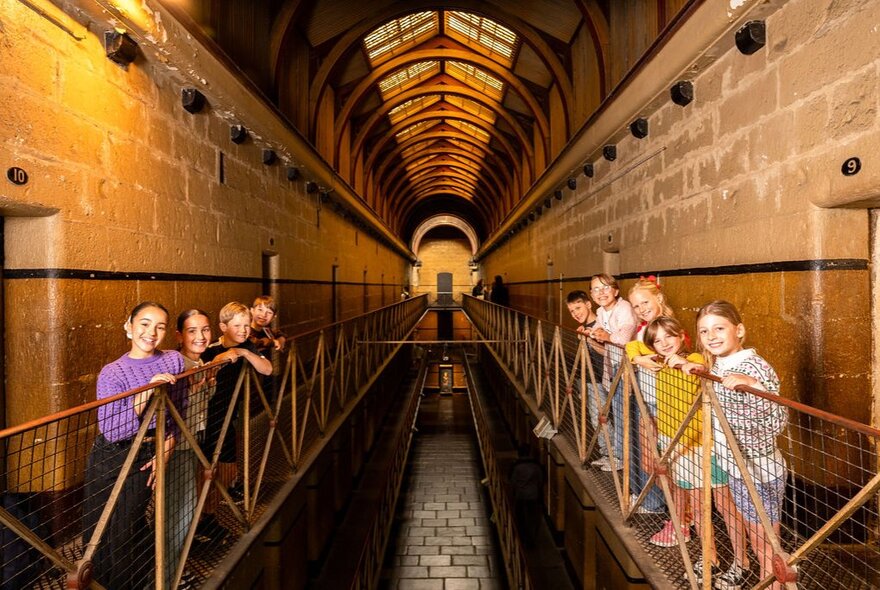 Children posing for a photo on the first floor walkways at the Old Melbourne Gaol.
