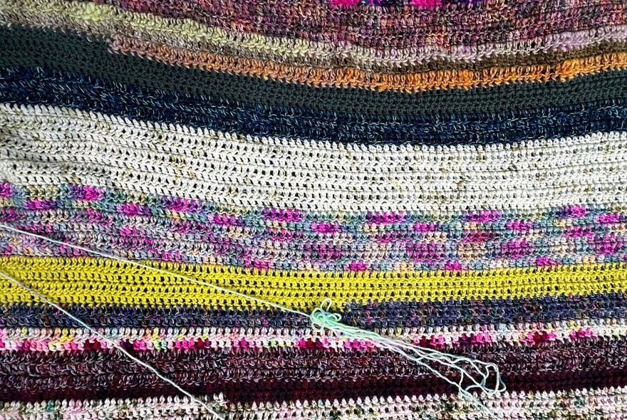 Woven artwork with coloured horizontal layers. 