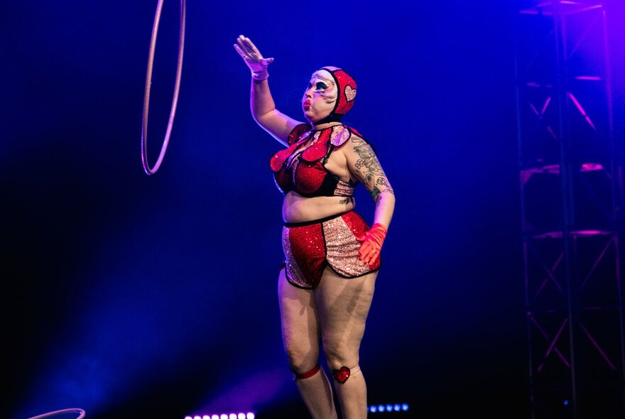 A burlesque dancer performing on stage with a hoop.