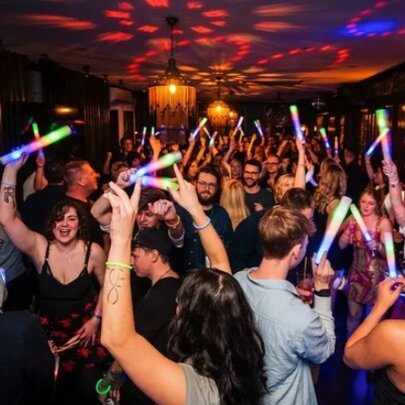 People dancing with fluro banners in a nightclub.