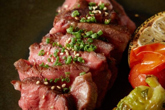 Sliced wagyu tartare with a green chimichurri sauce on top.