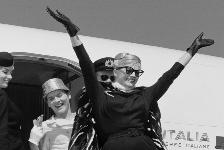 Actor Anita Ekberg emerging from an Alitalia airplane in a still from Fellini's movie La Dolce Vita.