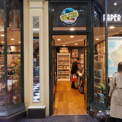 The facade of hand-crafted stationery store, Paper Republic, with a woman in a beige trench coat looking at the window.