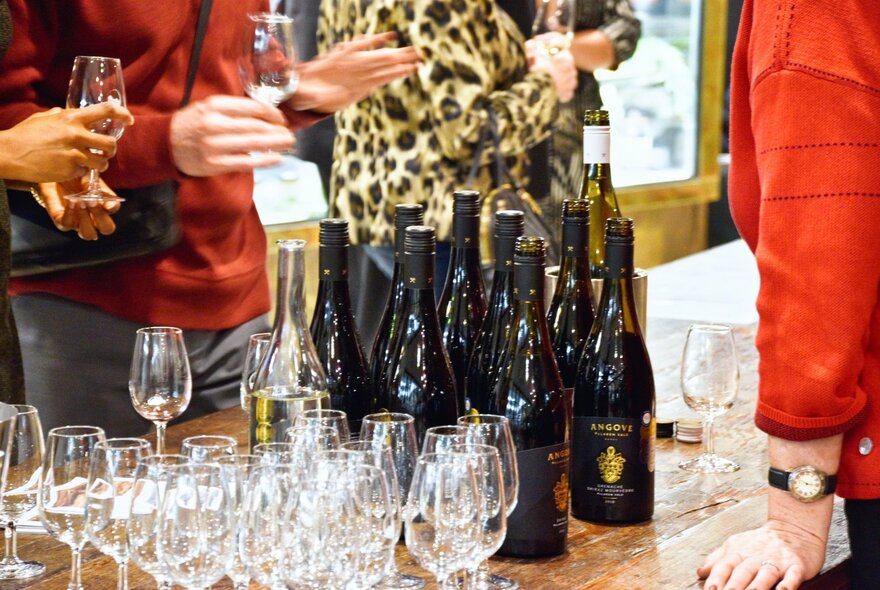 Rows of glasses and bottles on a wine-tasting counter.