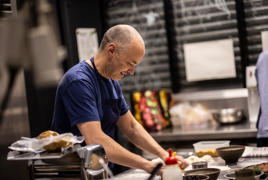 Chef Tobie Puttock cooking in a commercial kitchen at Queen Victoria Market.