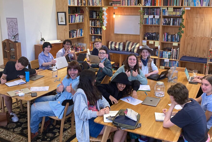 A classroom setting with young people working on two desks. 