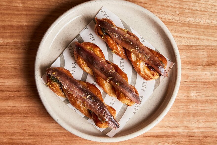 A plate with three anchovy toasts.